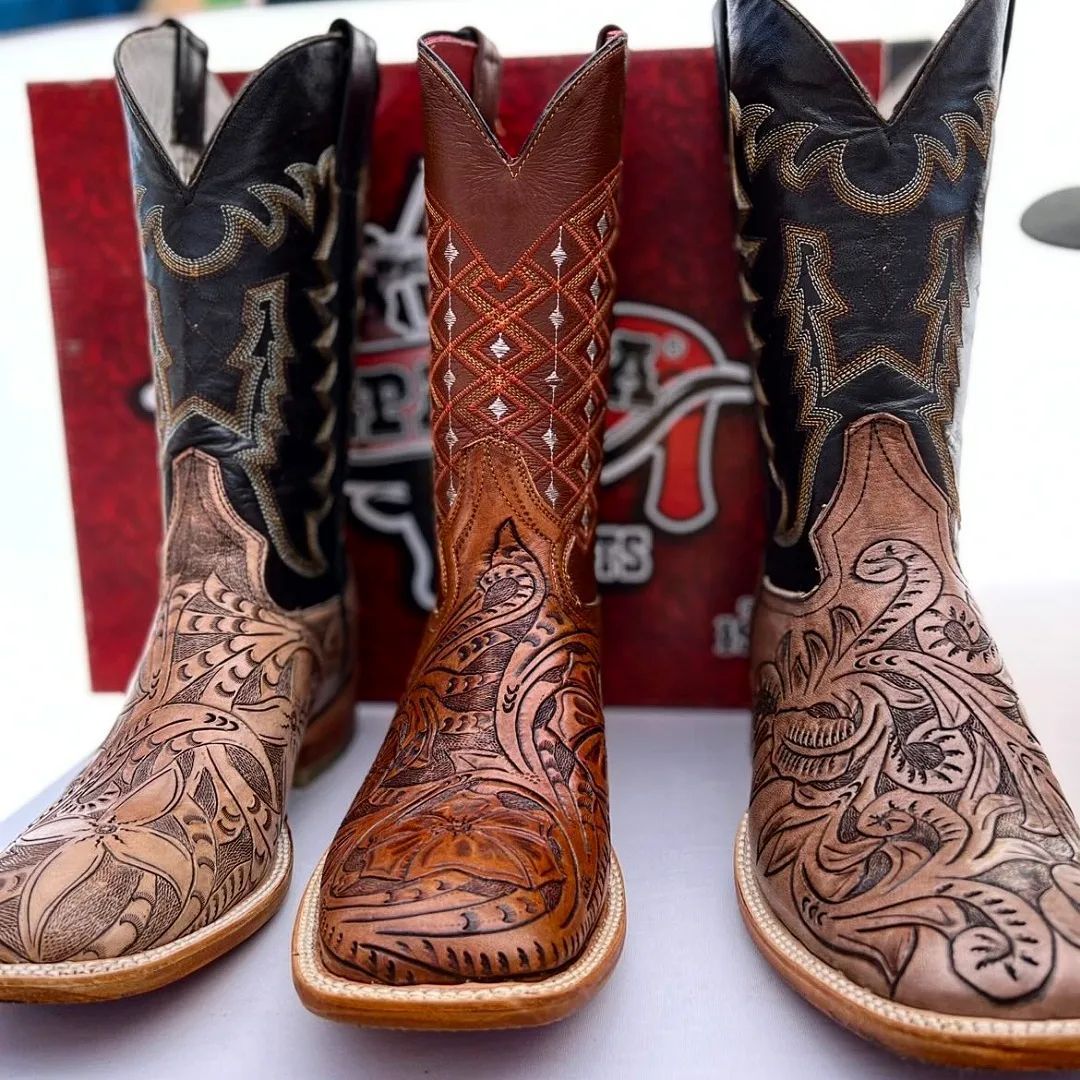 Three pairs of cowboy boots are lined up next to each other
