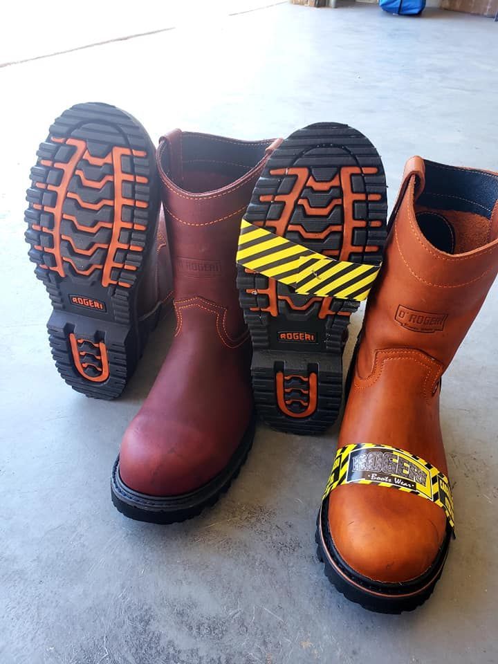 Three brown boots are sitting on a concrete floor.
