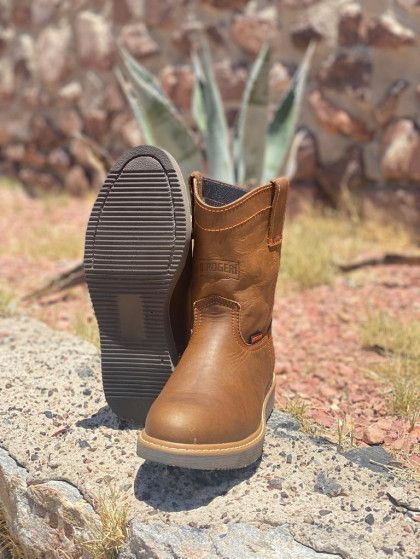 A pair of brown cowboy boots are sitting on top of a rock.