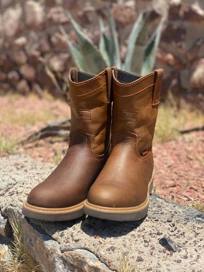 A pair of brown cowboy boots are sitting on top of a rock.