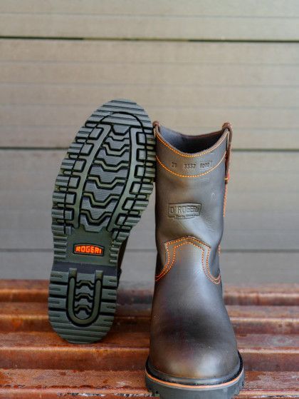 A pair of brown boots are sitting on a wooden bench.