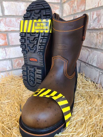 A pair of brown boots are sitting on a pile of hay.