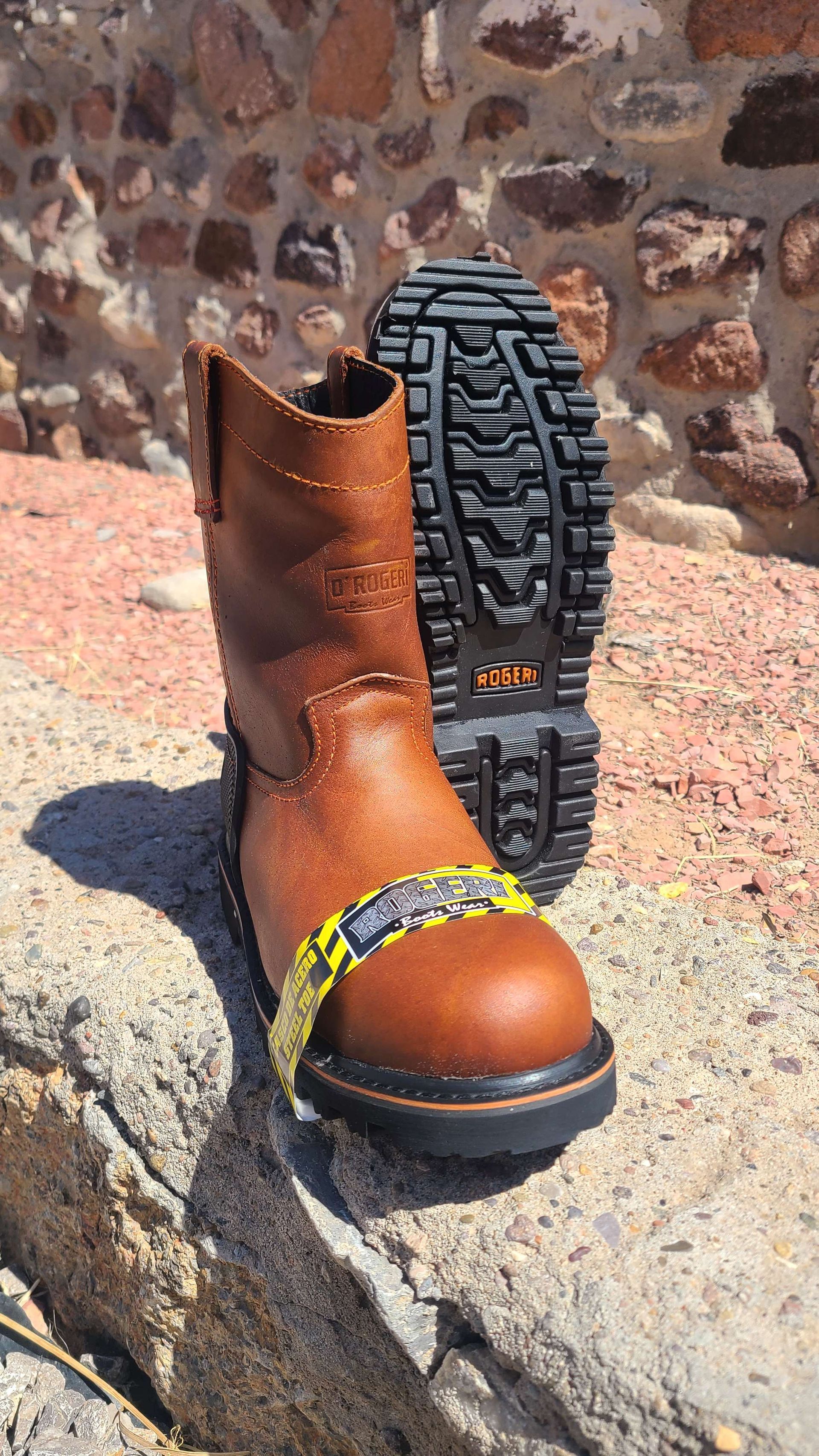 A pair of brown boots are sitting on top of a rock.