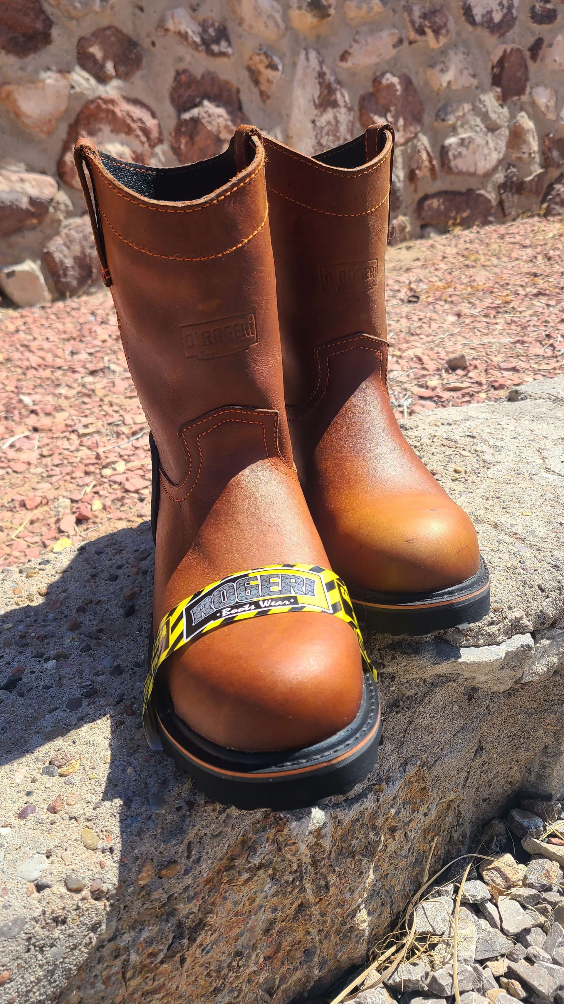 A pair of brown boots are sitting on top of a rock.