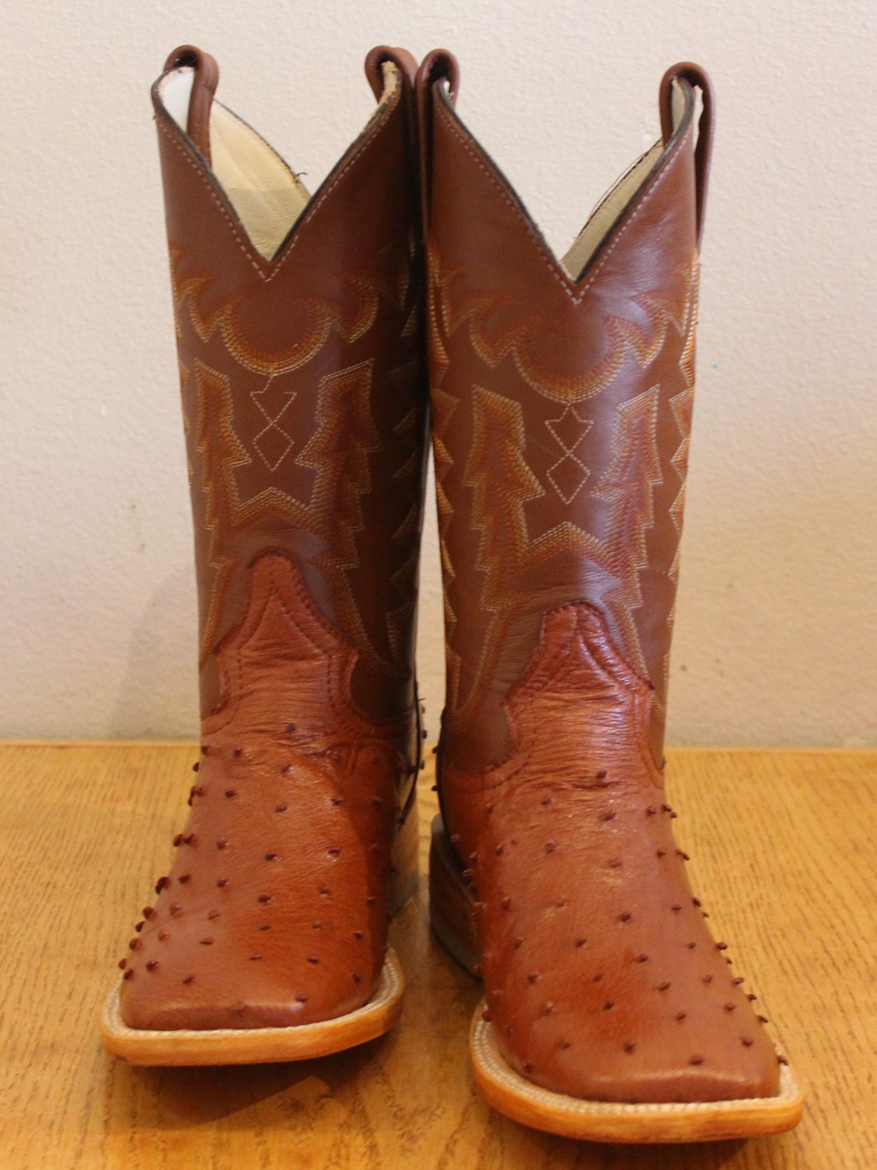 A pair of brown cowboy boots on a wooden table