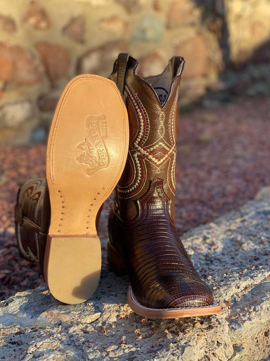 A pair of brown cowboy boots are sitting on top of a rock.