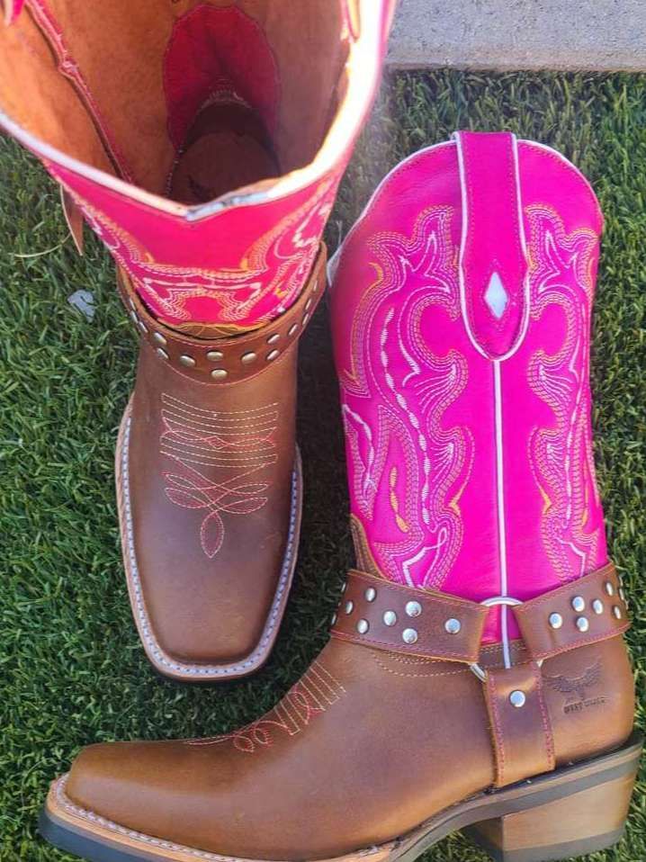 A pair of brown cowboy boots next to a pair of pink cowboy boots