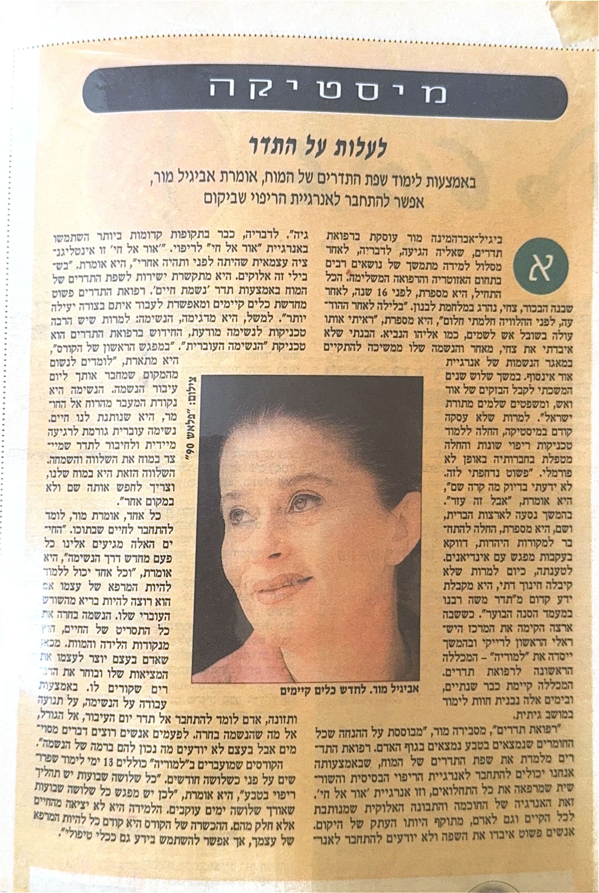 כתבה בעיתון בעברית עם תמונה של אביגיל מור במרכזה – טקסט צפוף סביב תמונה מודפסת בגווני כתום-חום
