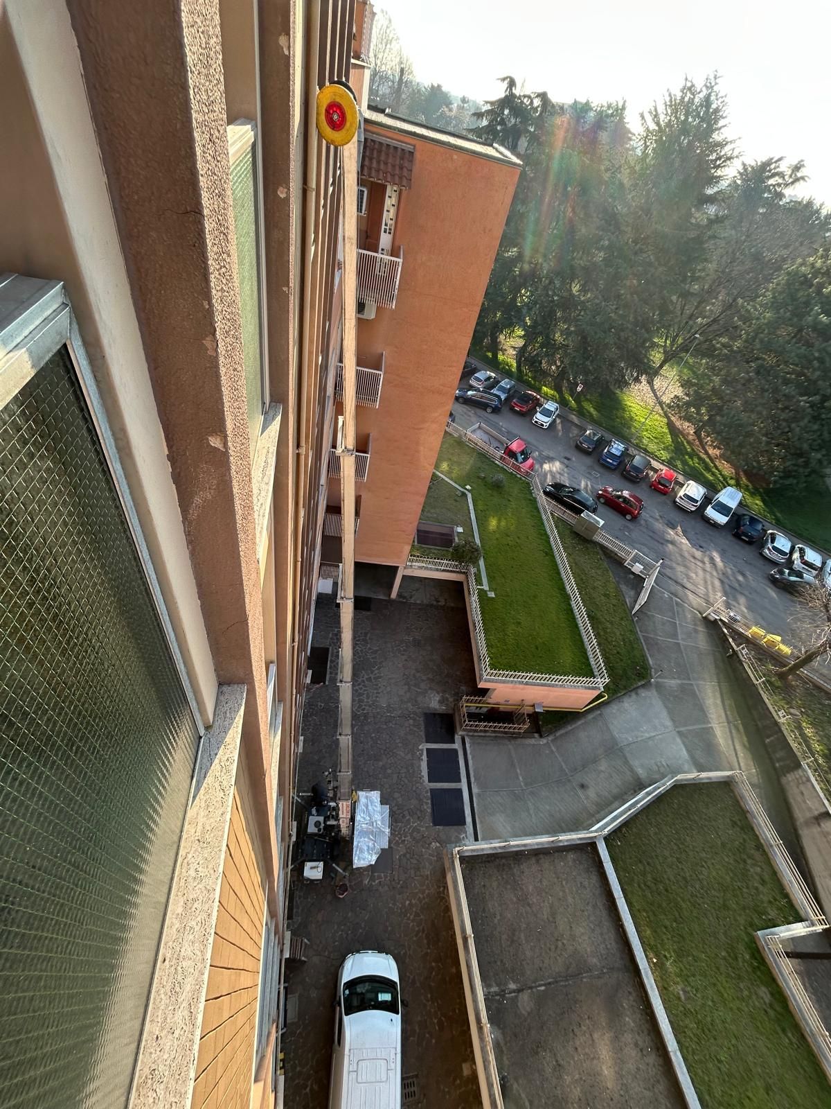 Autogru che scarica mobili in un condominio a più piani. Persona che carica. Giornata di sole.