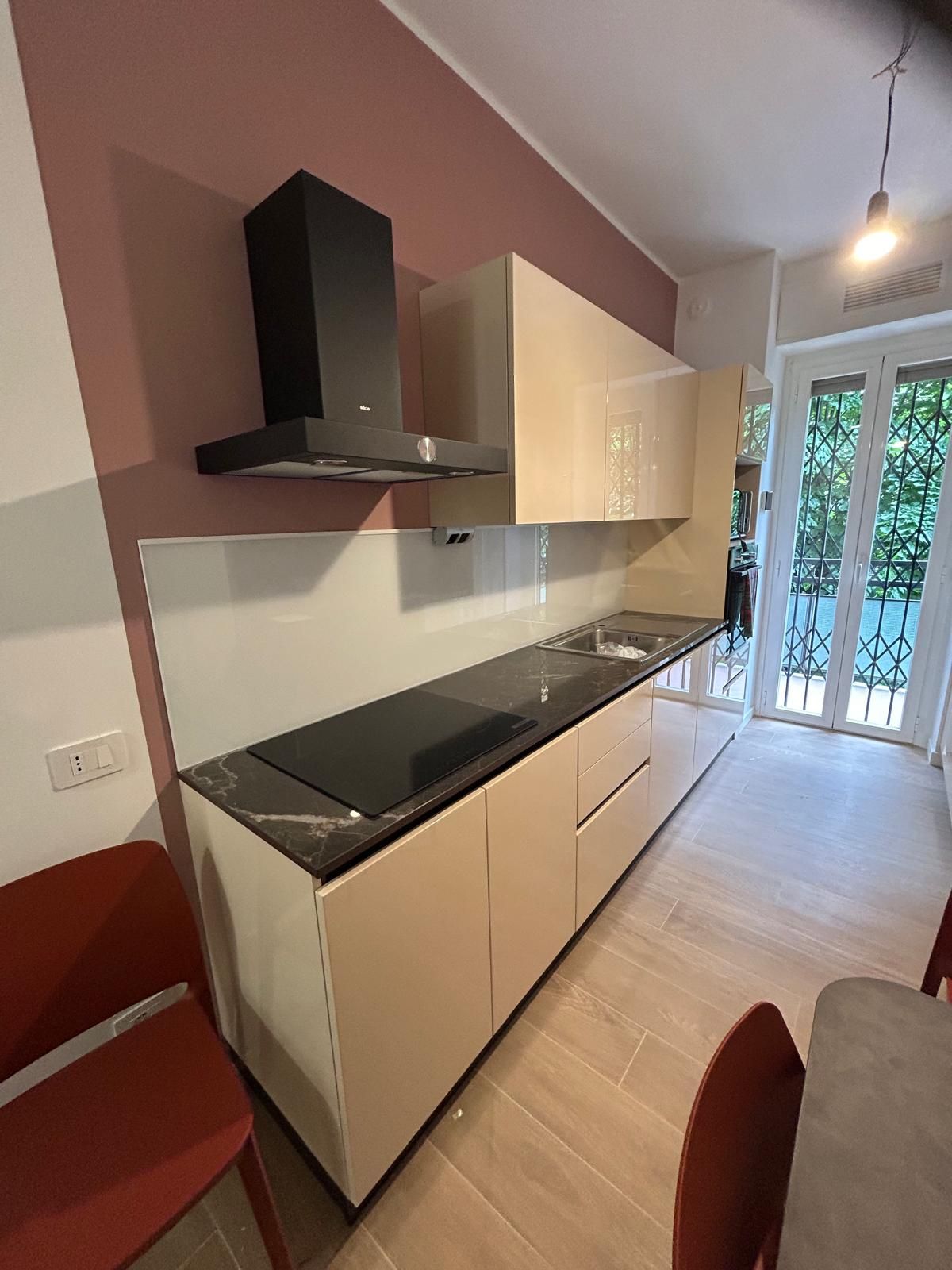 Stanza vuota con pareti color lavanda, pavimento piastrellato beige e una finestra; aria condizionata.