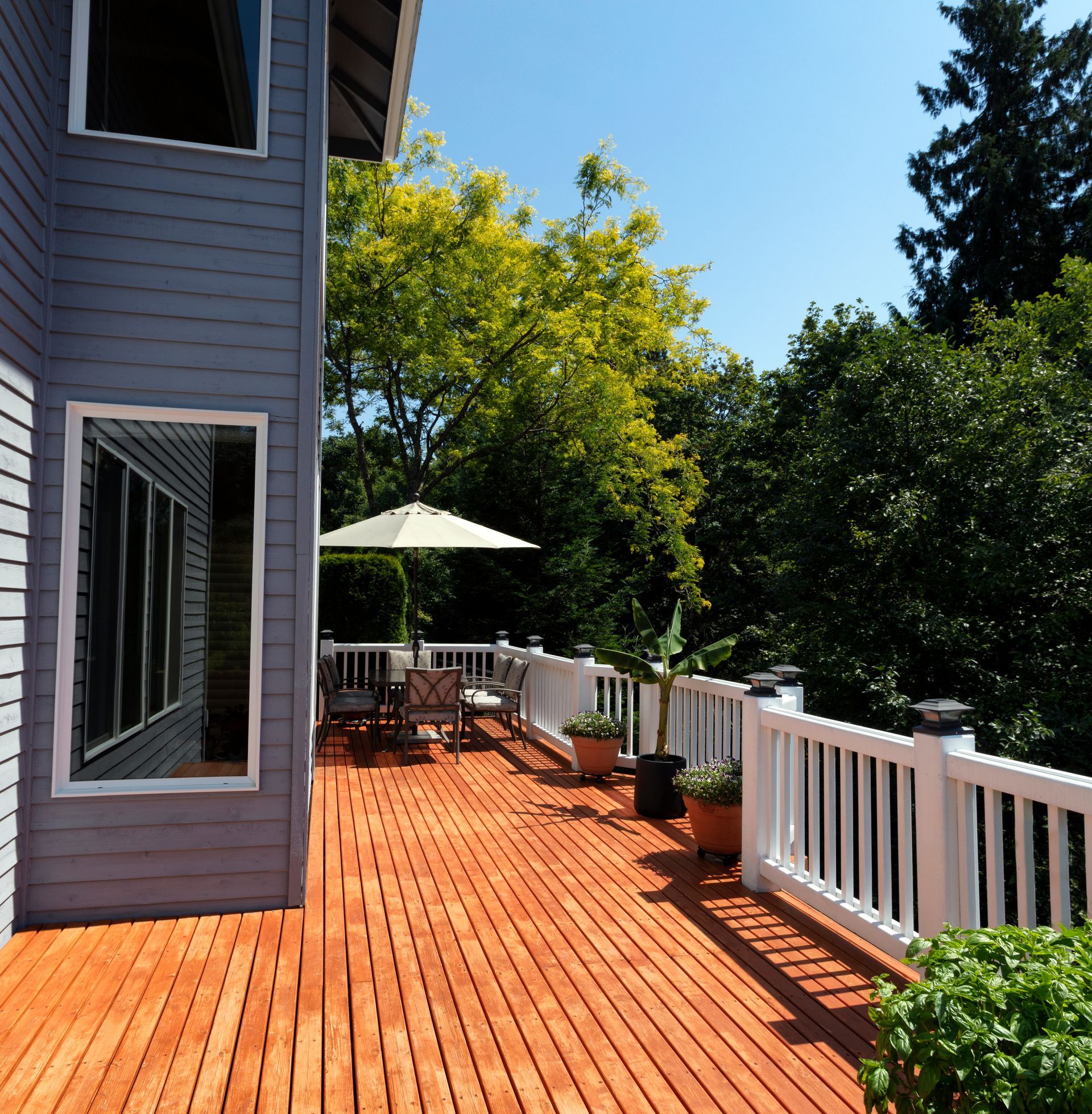 Outdoor home wooden deck during lovely summer day with seasonal garden