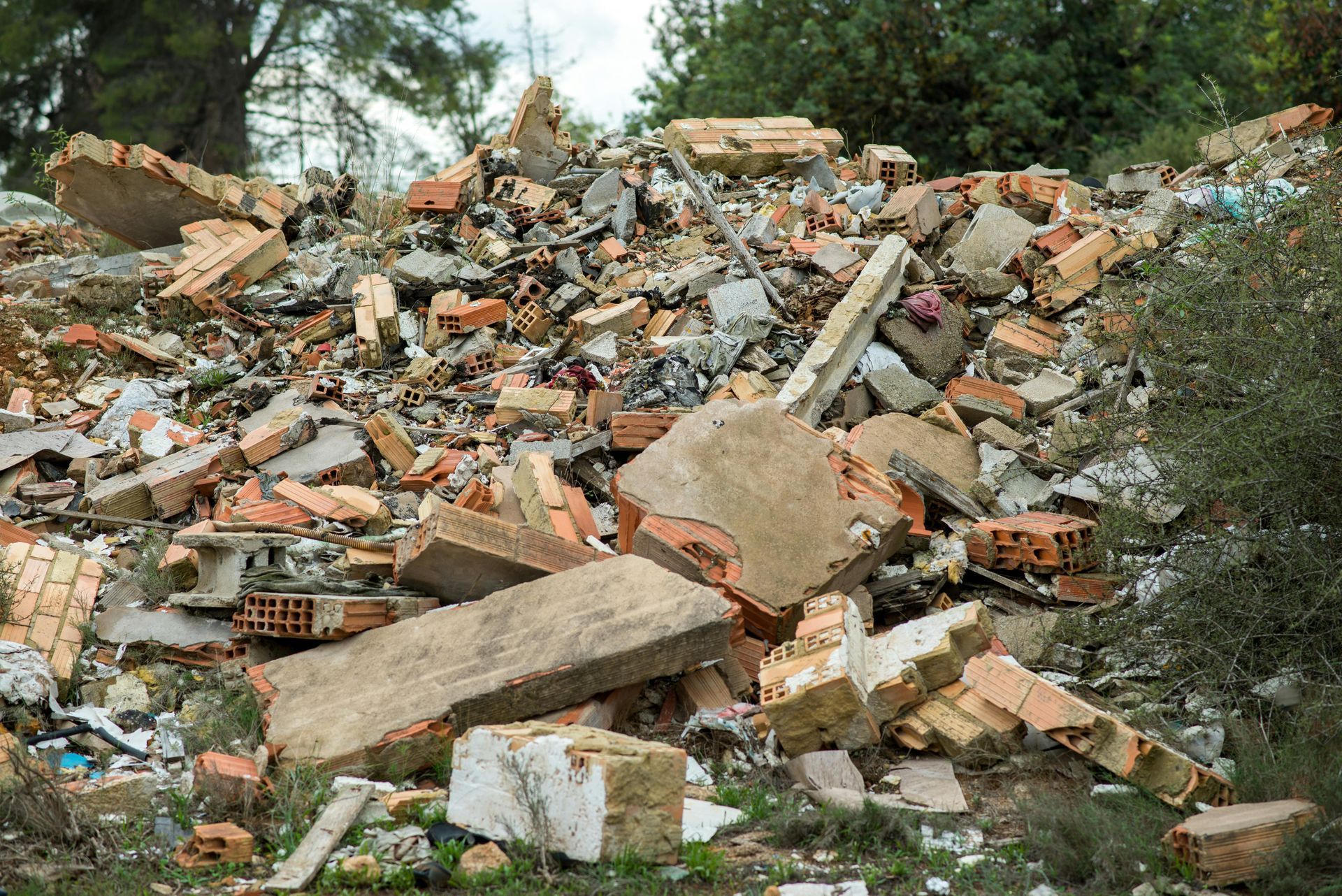 A pile of rubble is sitting on top of a grassy hill.