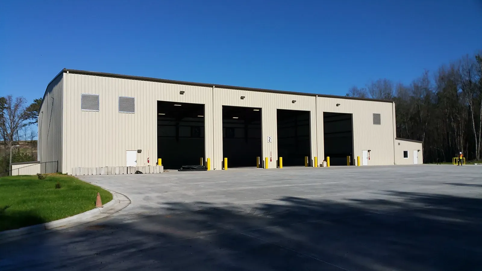 A large building with a lot of doors and a parking lot in front of it.