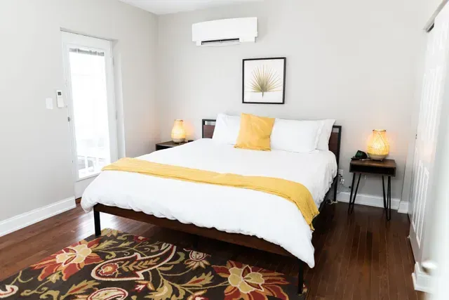 Bright bedroom with yellow throw pillows and minimalist decor