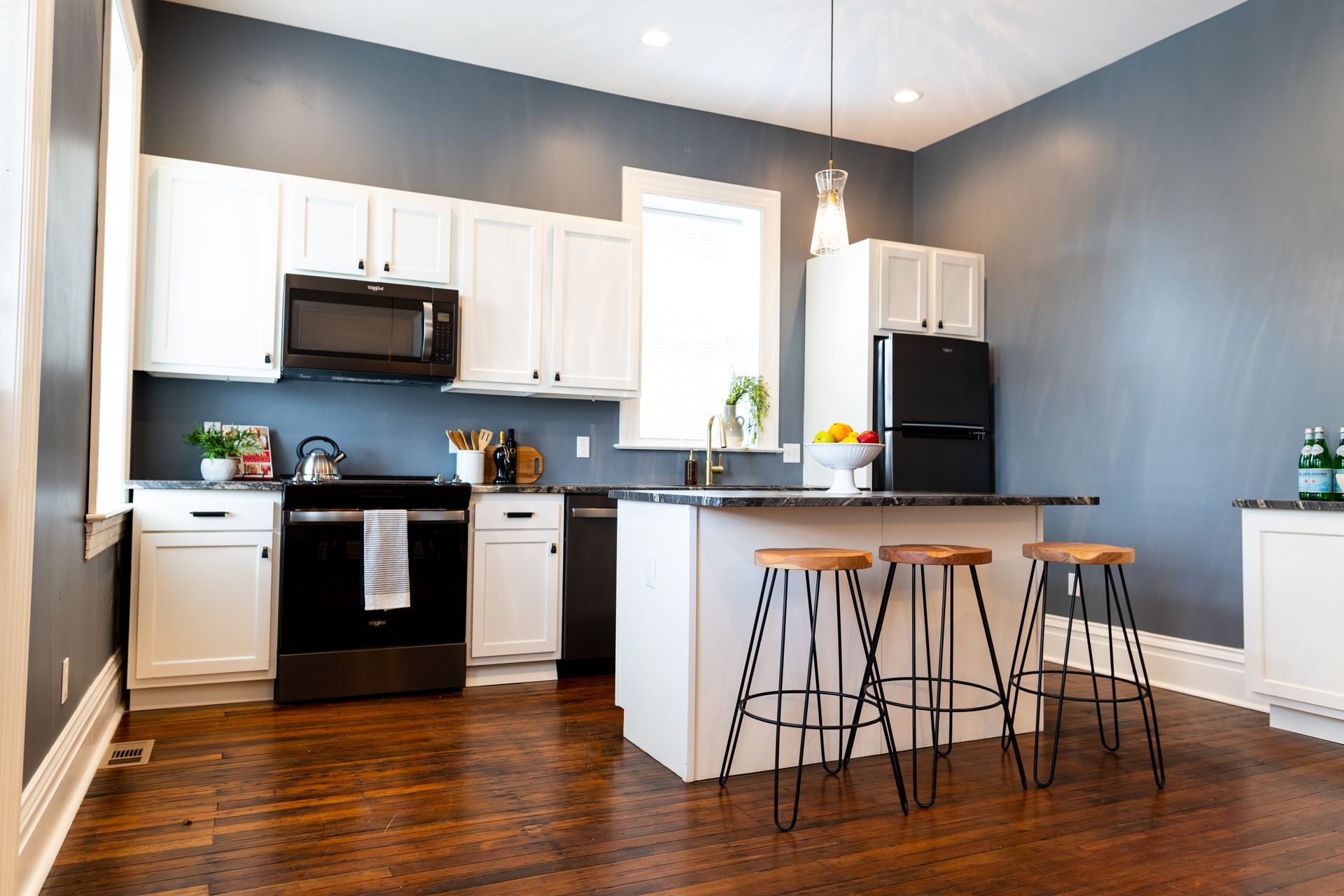 Contemporary open kitchen with breakfast bar and navy accent wall