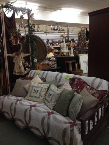 Cozy living room with a patterned sofa, decorative pillows, and shelves of home decor in the background