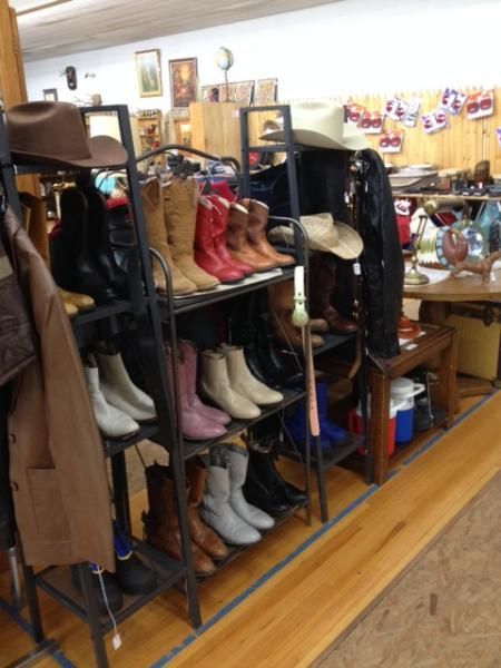 Shoe display with boots and heels on black shelving inside a store