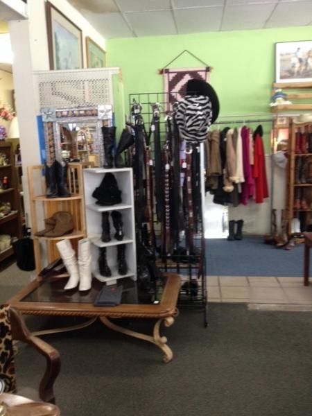 Clothing boutique interior with racks of dresses, boots, and accessories on display