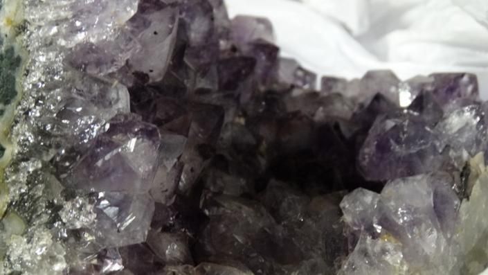 Purple and clear crystals in a rocky mineral cluster