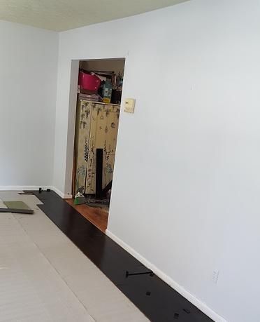 A living room with hardwood floors and white walls.
