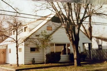 A white house with a tree in front of it