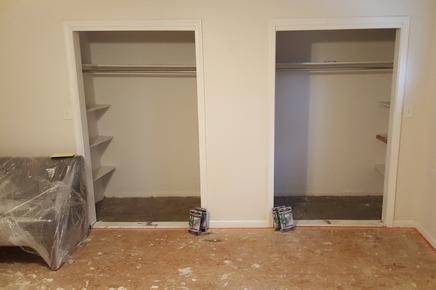 There are two closets in the room , one of which is empty.