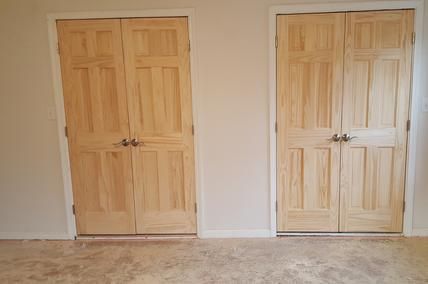 Two wooden doors are in a room next to each other.