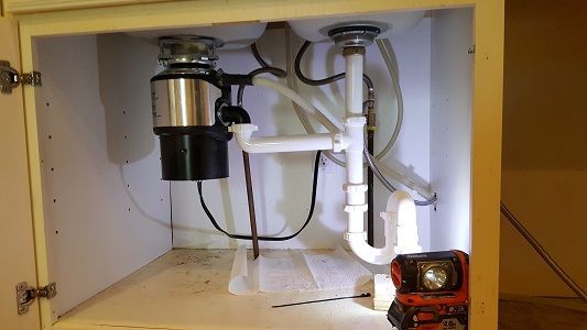 There is a garbage disposal under the sink in the cabinet.