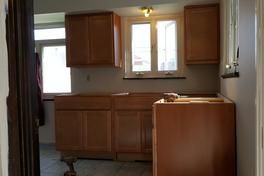 A kitchen with wooden cabinets and a washer and dryer.
