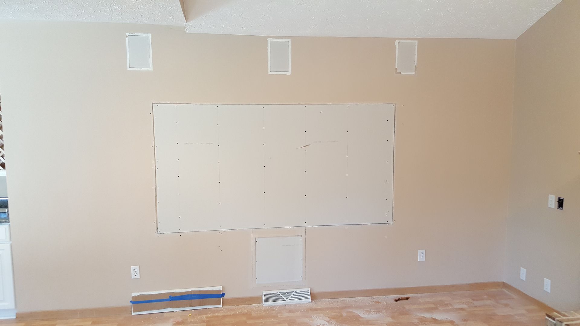 A living room with a large white board on the wall.
