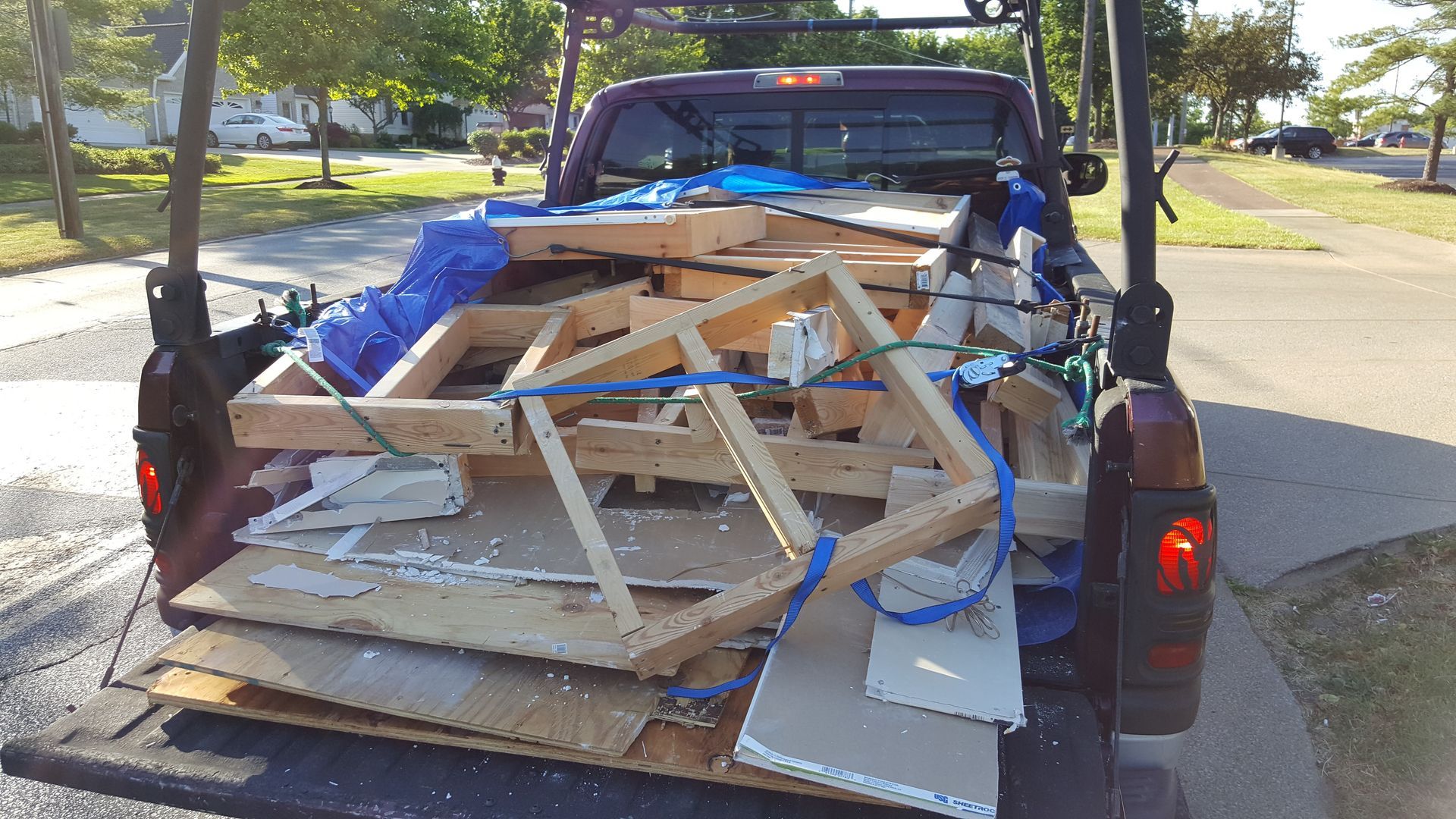 A purple truck is loaded with a lot of wood
