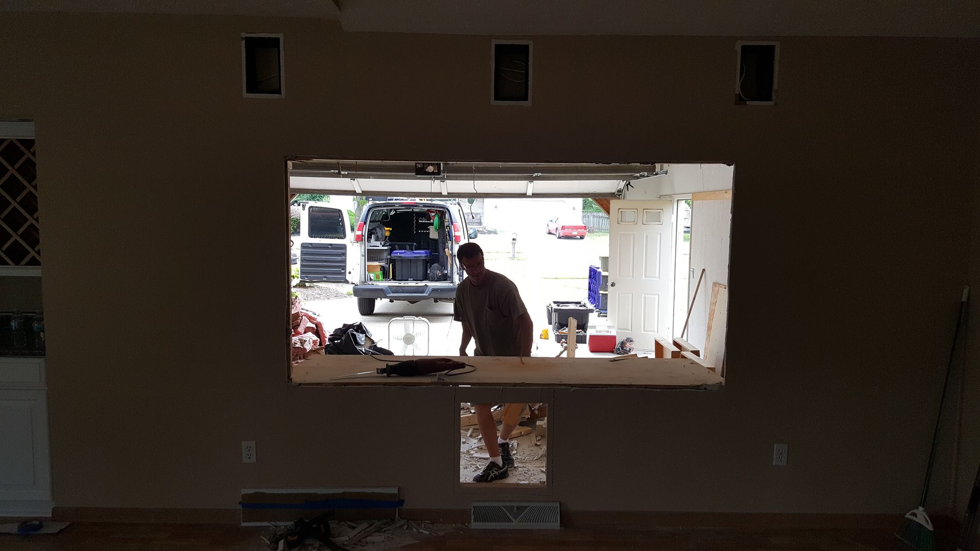 A man is standing in front of a garage door.