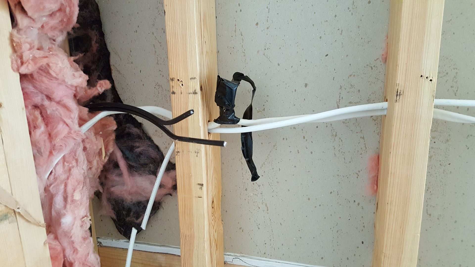 A bunch of wires are hanging from a wooden frame.