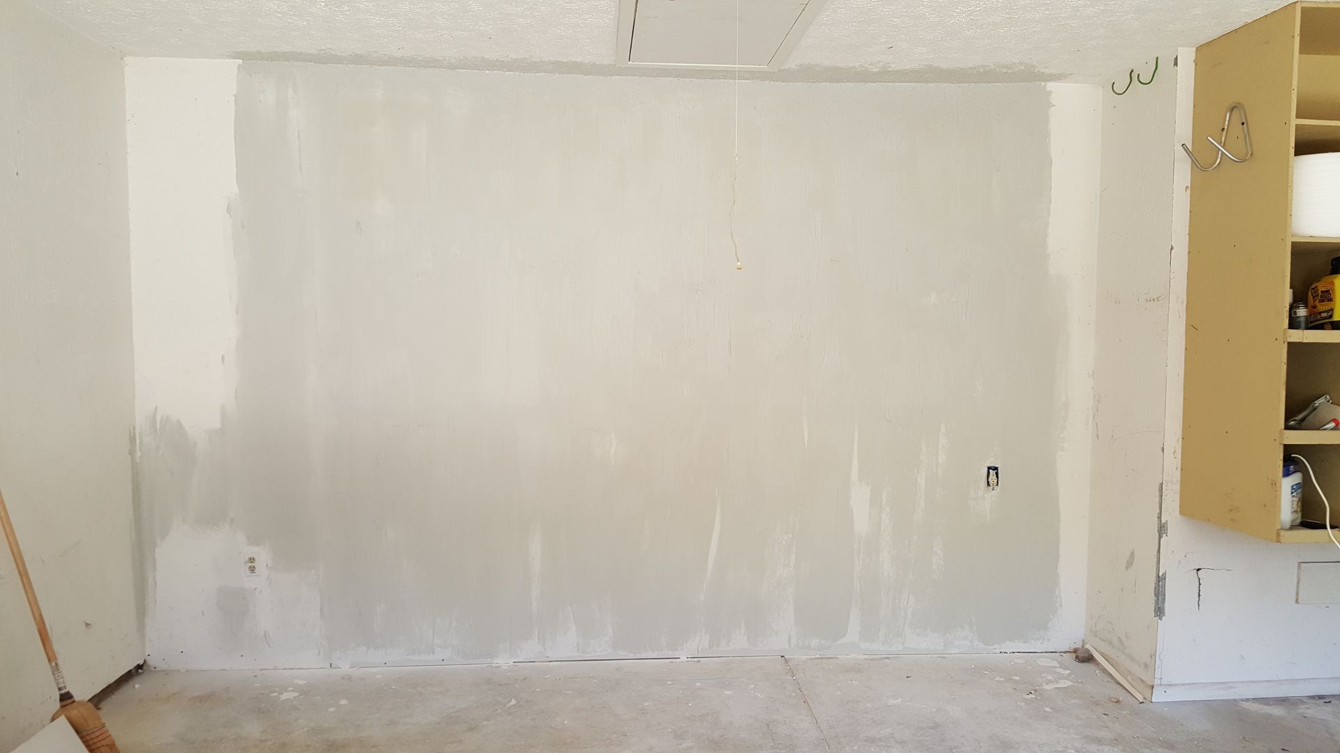 A room with a large white wall and a door.