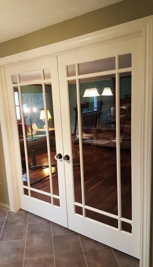 A pair of french doors leading into a living room.