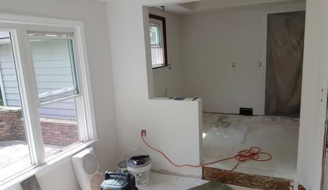 A room with a lot of windows and a vacuum cleaner in it.