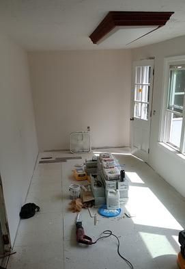 A room with a table and a vacuum cleaner on the floor.