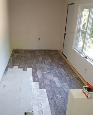 A room with a wooden floor and a window.