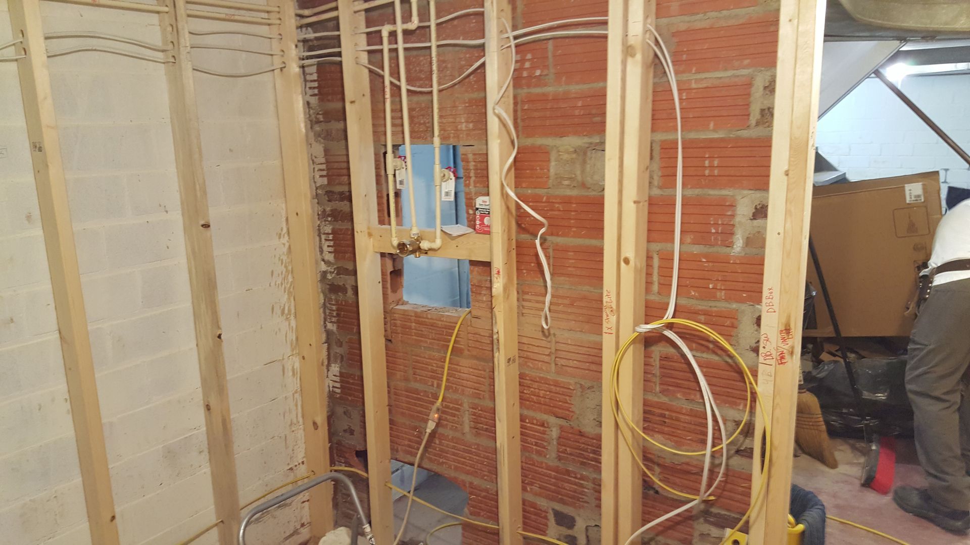 A brick wall with wooden beams and wires coming out of it.