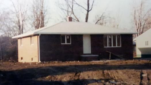 A black and white photo of a house with a white roof