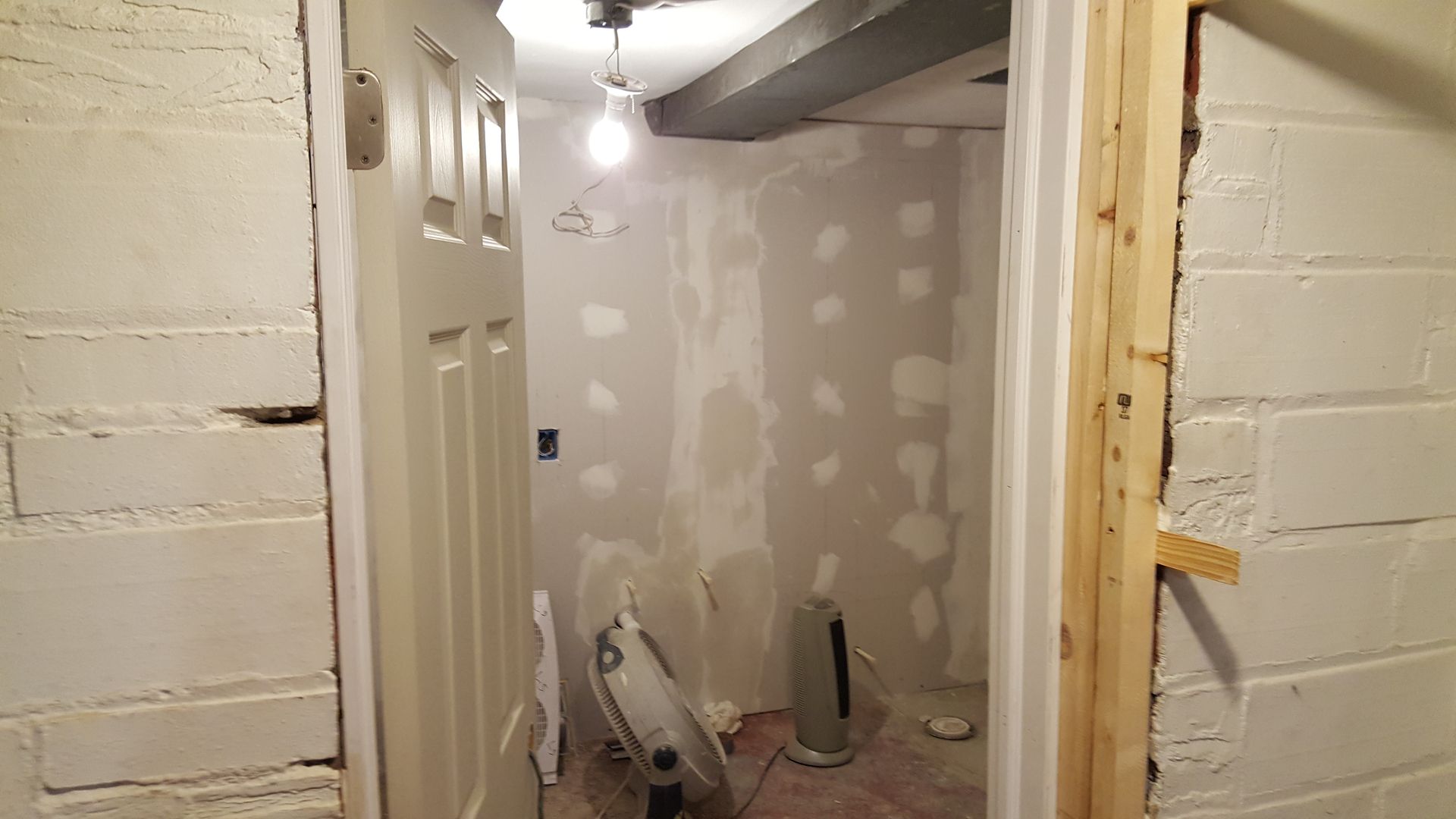 A room with a door and a fan in it.