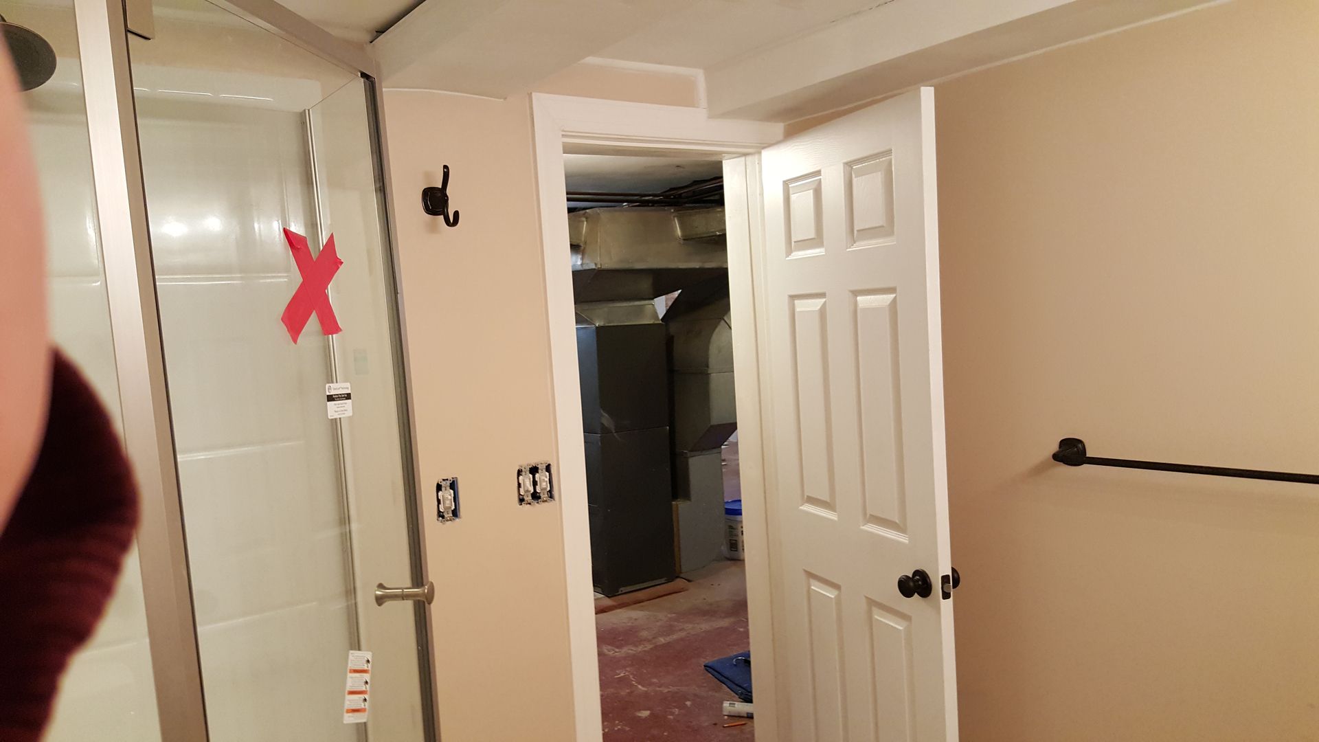 A person is taking a picture of a bathroom with a door open.