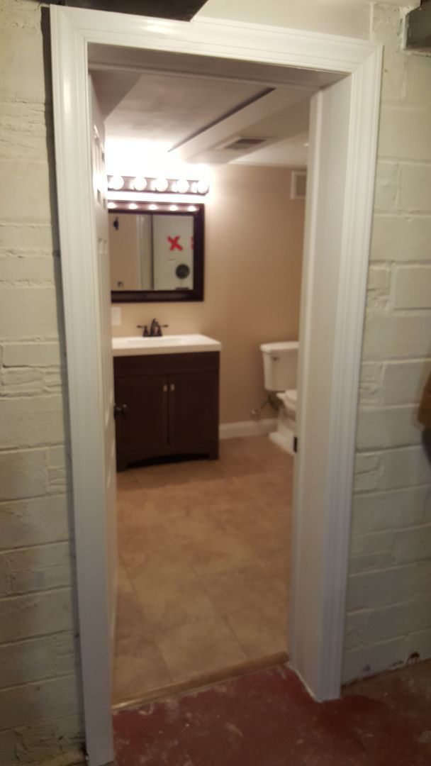 A bathroom with a sink , toilet and mirror.
