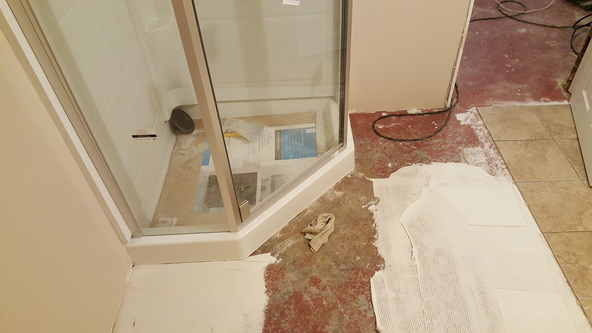 A shower stall is being installed in a bathroom.