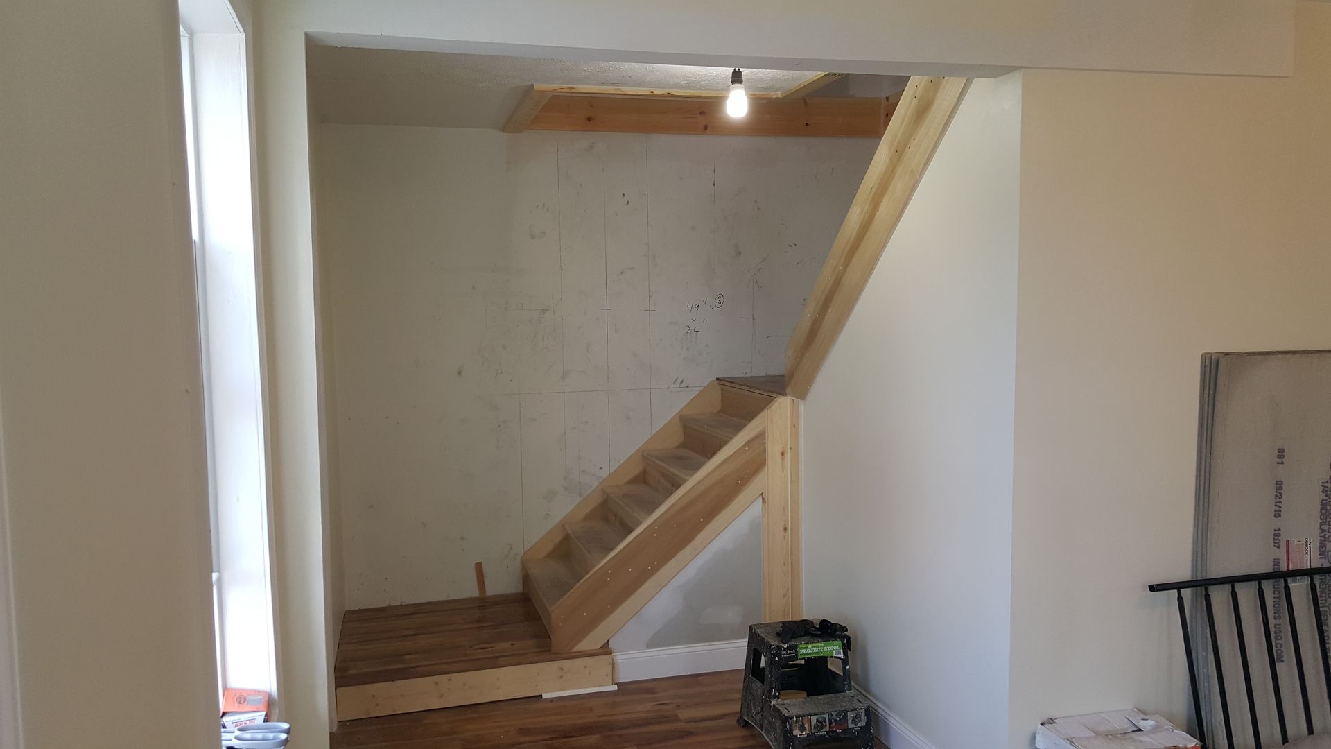 A wooden staircase is being built in a room.