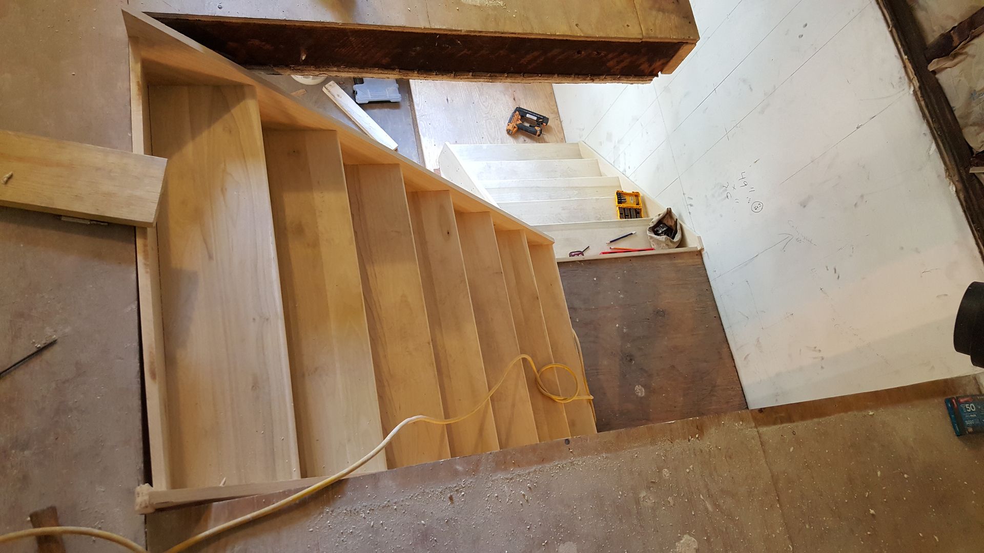 A wooden staircase is being built in a room.