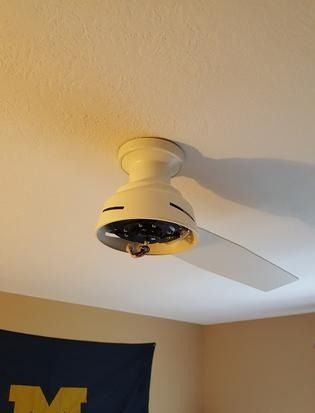 A ceiling fan is hanging from the ceiling in a room