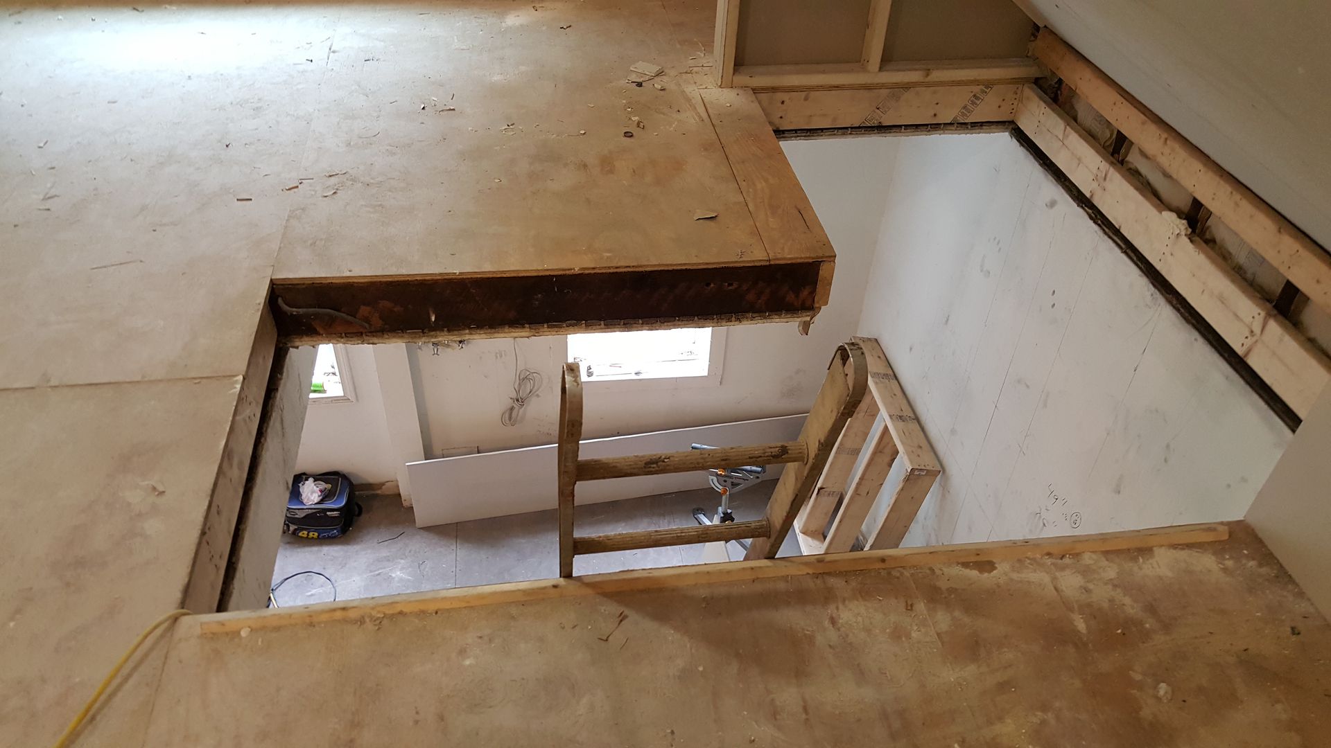 A wooden ladder is sitting in the middle of a room.