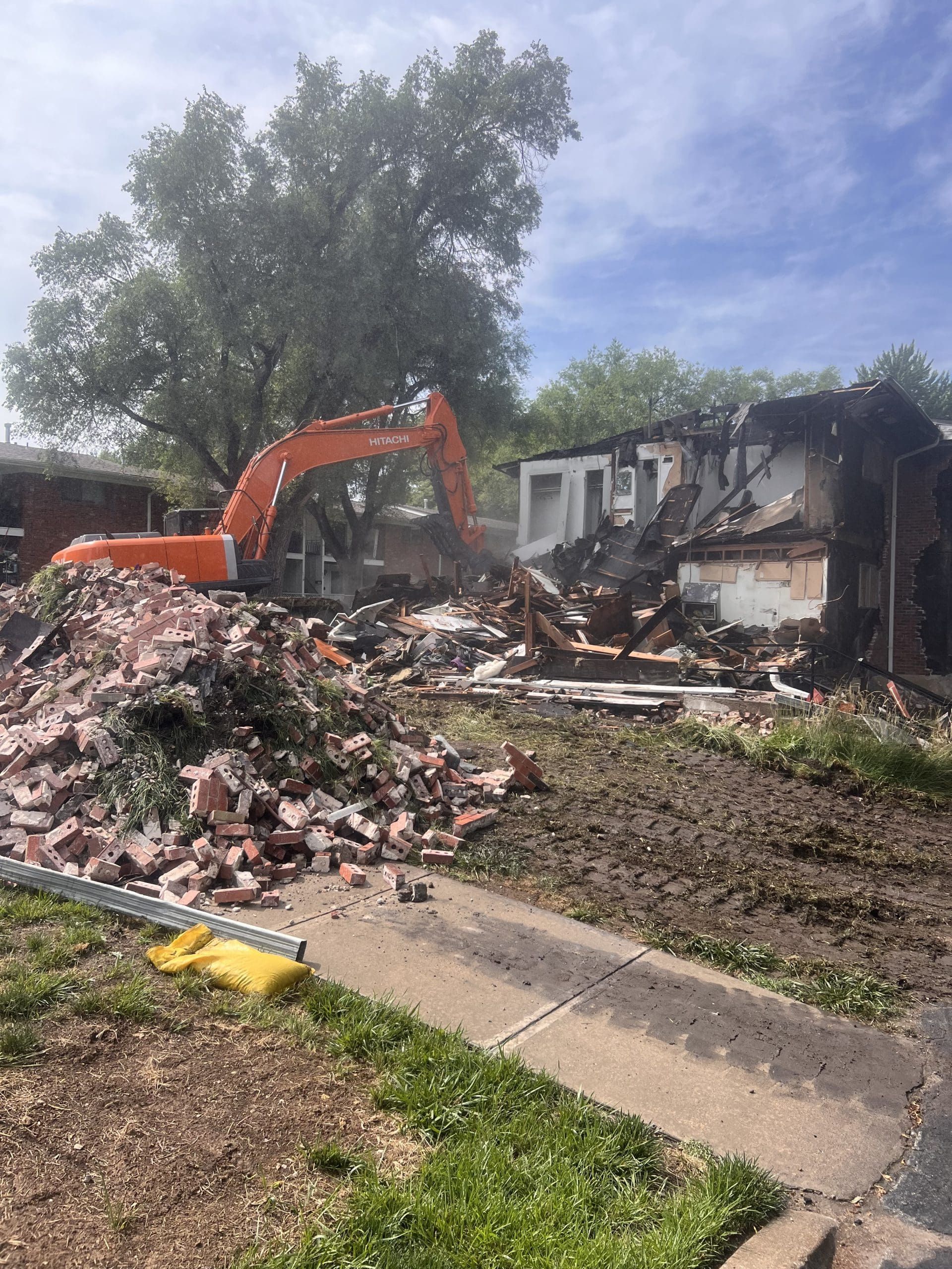 A house is being demolished by an excavator.