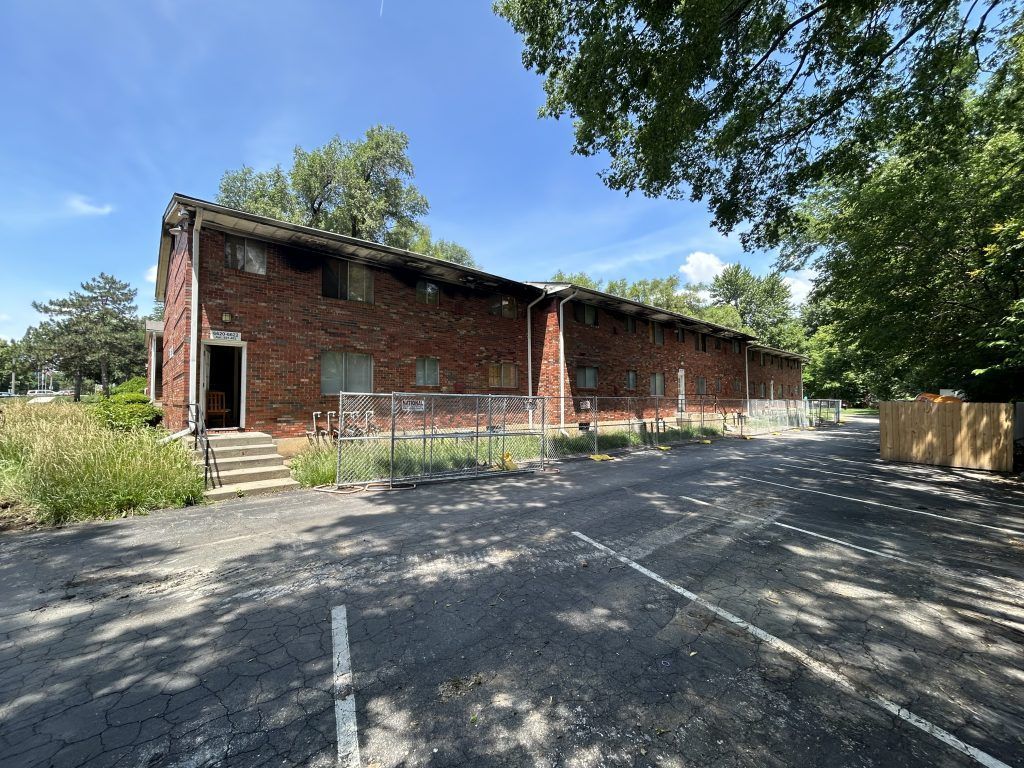 A large brick building with a parking lot in front of it.